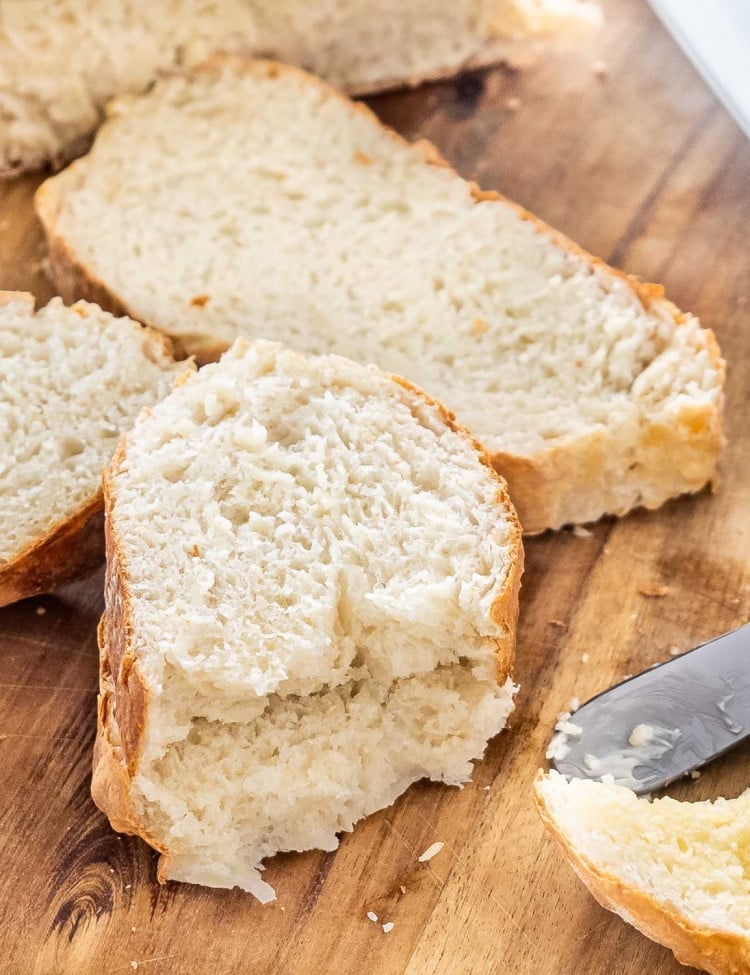 freshly made bread in air fryer on a cutting board cut into slices.