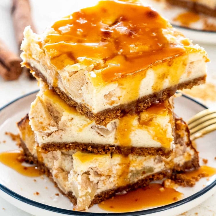 a stack of 3 apple pie cheesecake bars drizzled with salted caramel.
