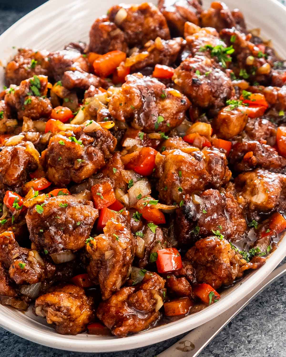 black pepper chicken in a white serving platter.