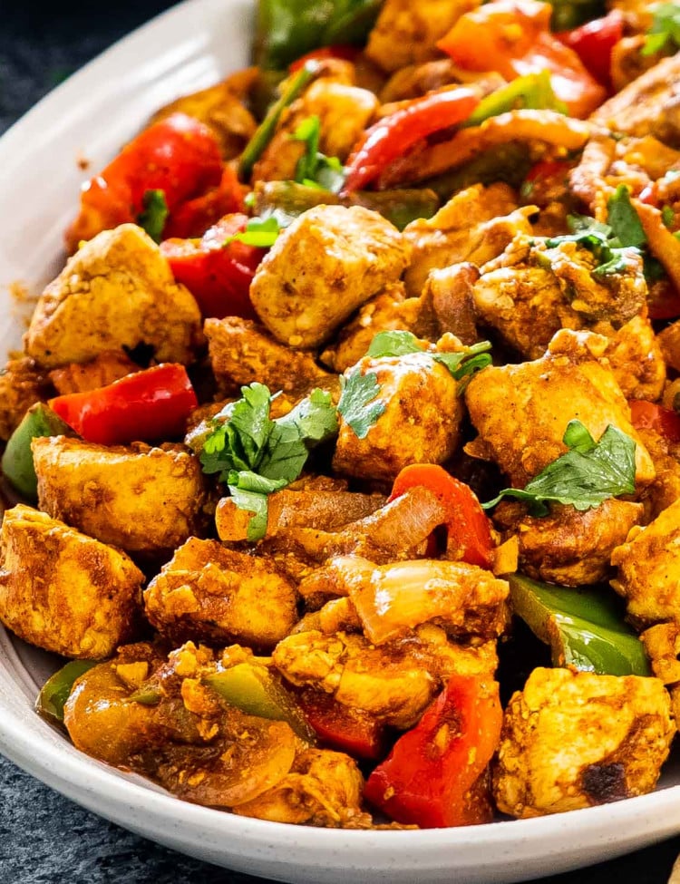chicken jalfrezi on a white silver platter.