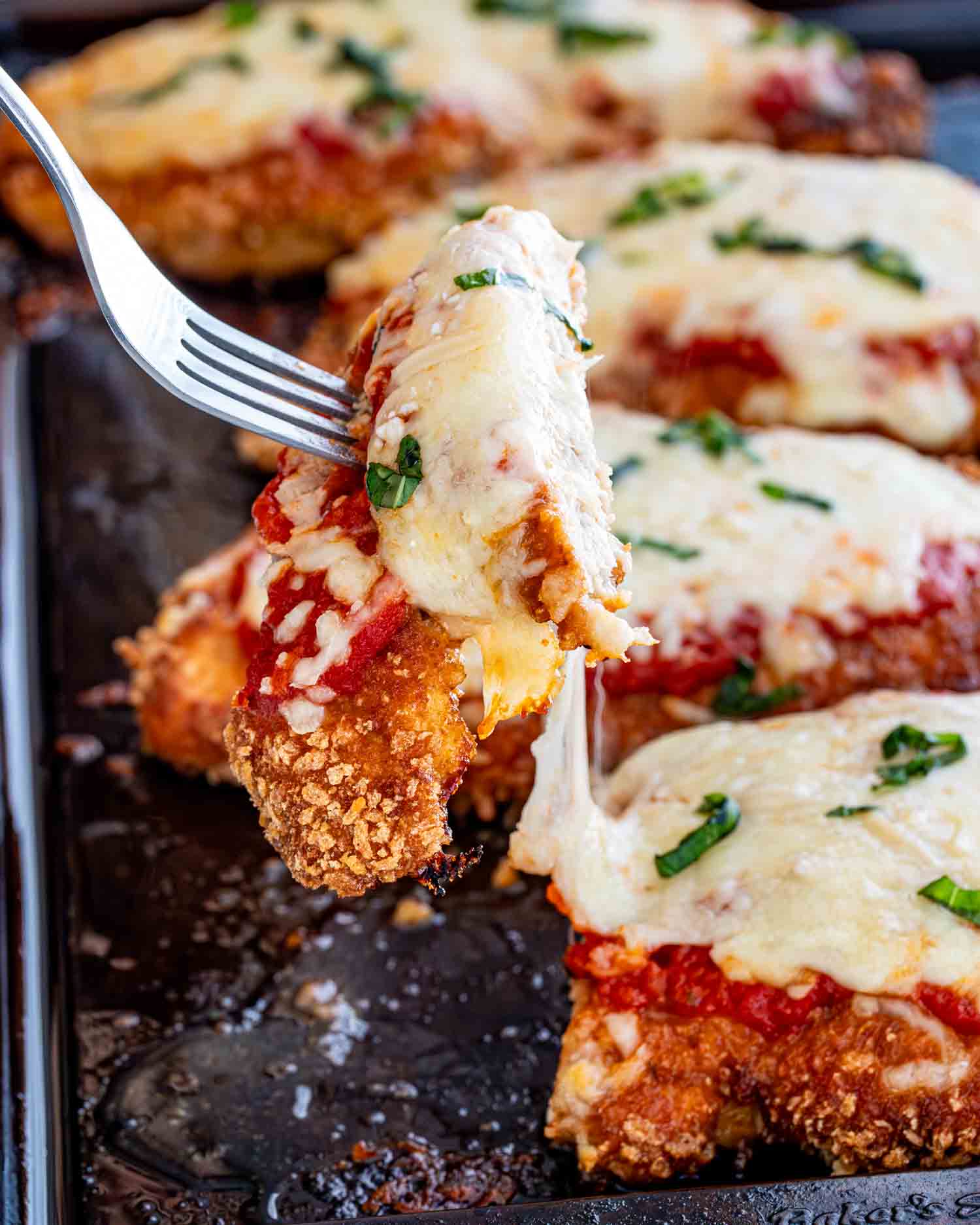 chicken parmesan fresh out of the oven on a baking sheet.
