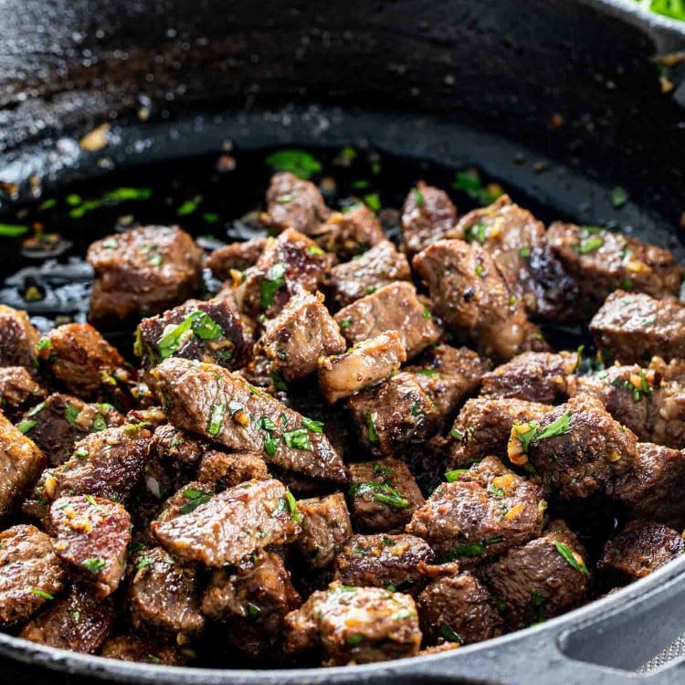 garlic butter steak bites in a black cast iron skillet.