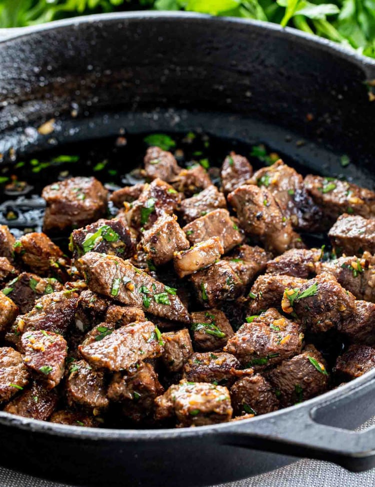 garlic butter steak bites in a black cast iron skillet.