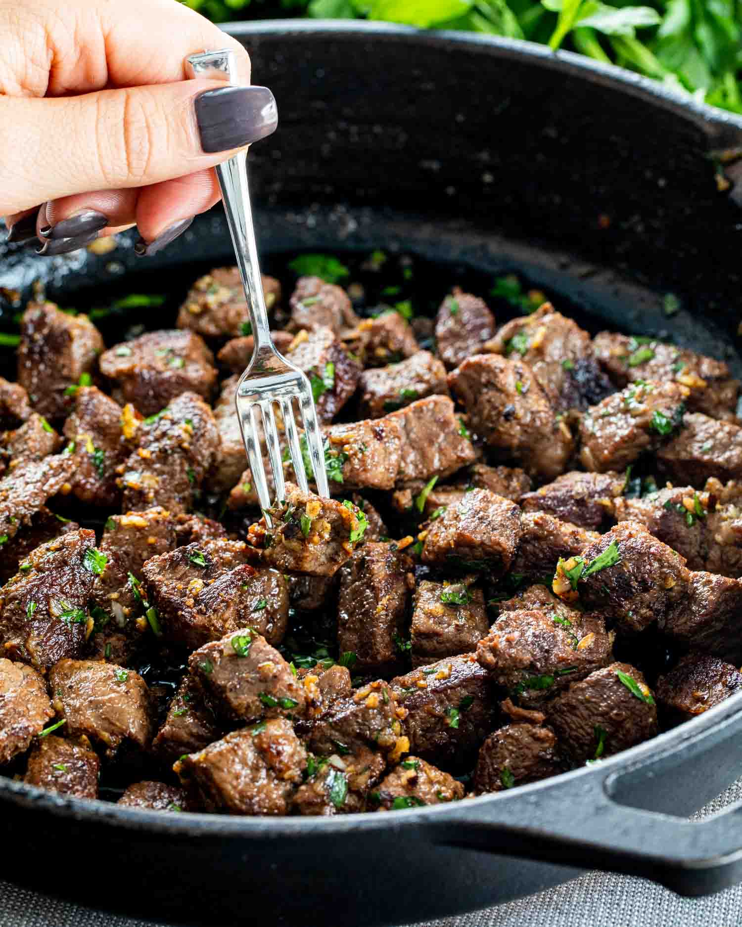 garlic butter steak bites in a black cast iron skillet.