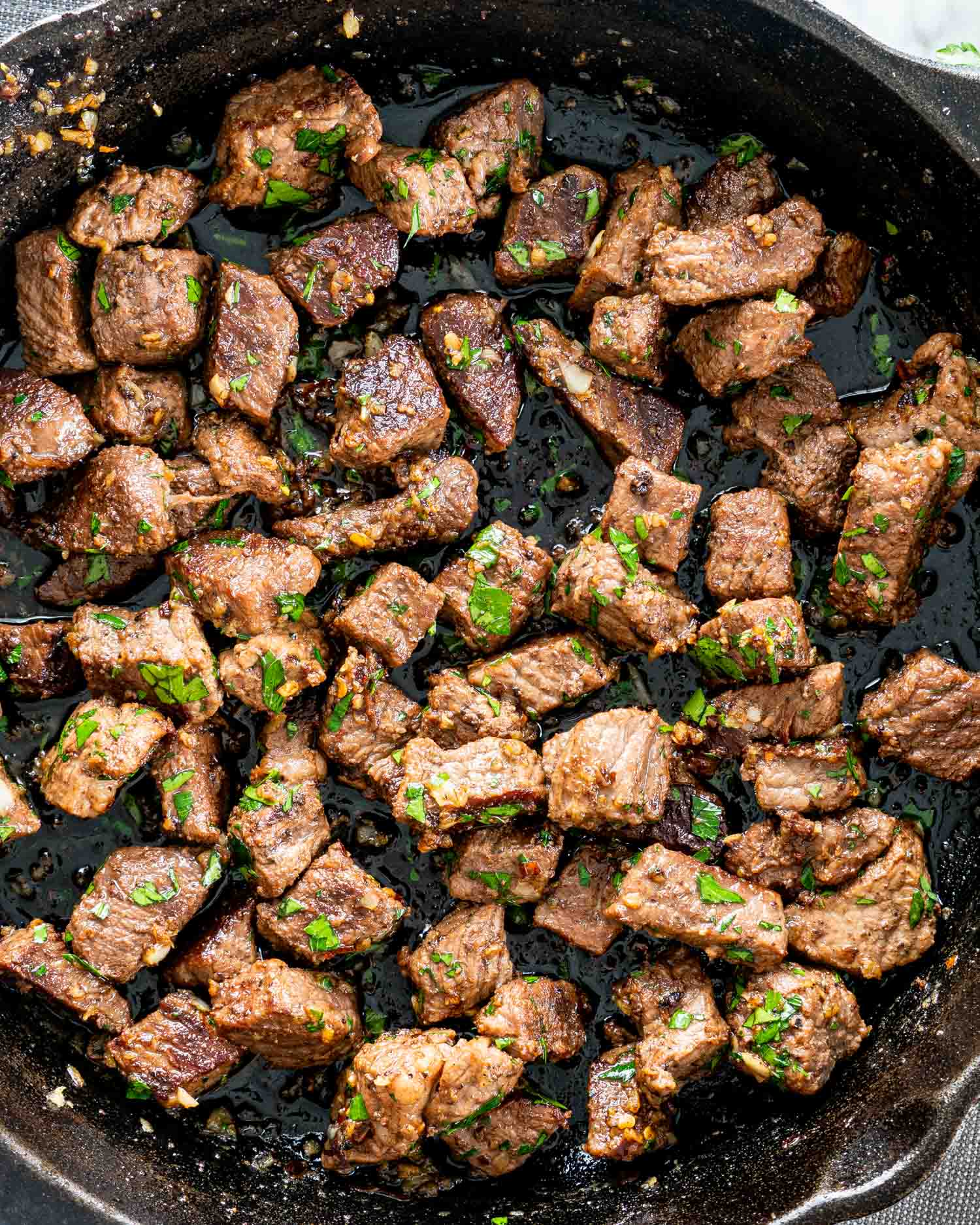 garlic butter steak bites in a black cast iron skillet.