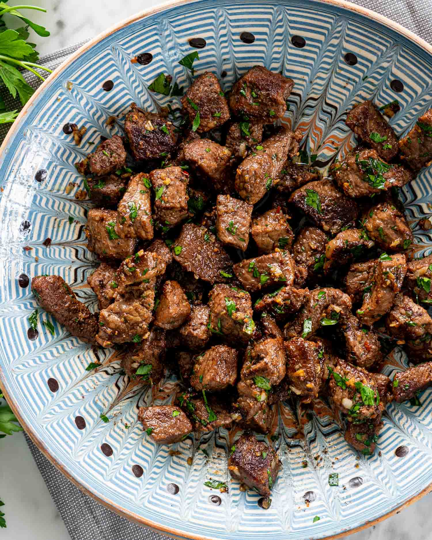 garlic butter steak bites in a blue bowl.