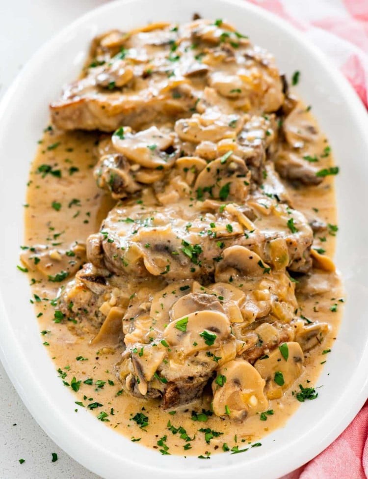 pork chops with mushroom gravy on a serving platter.