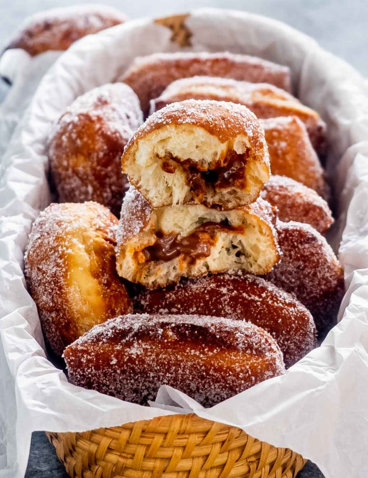 sugar coated malasadas in a basket.