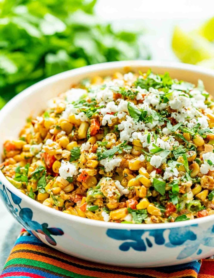 mexican street corn salad in a bowl garnished with cilantro and cotija cheese.