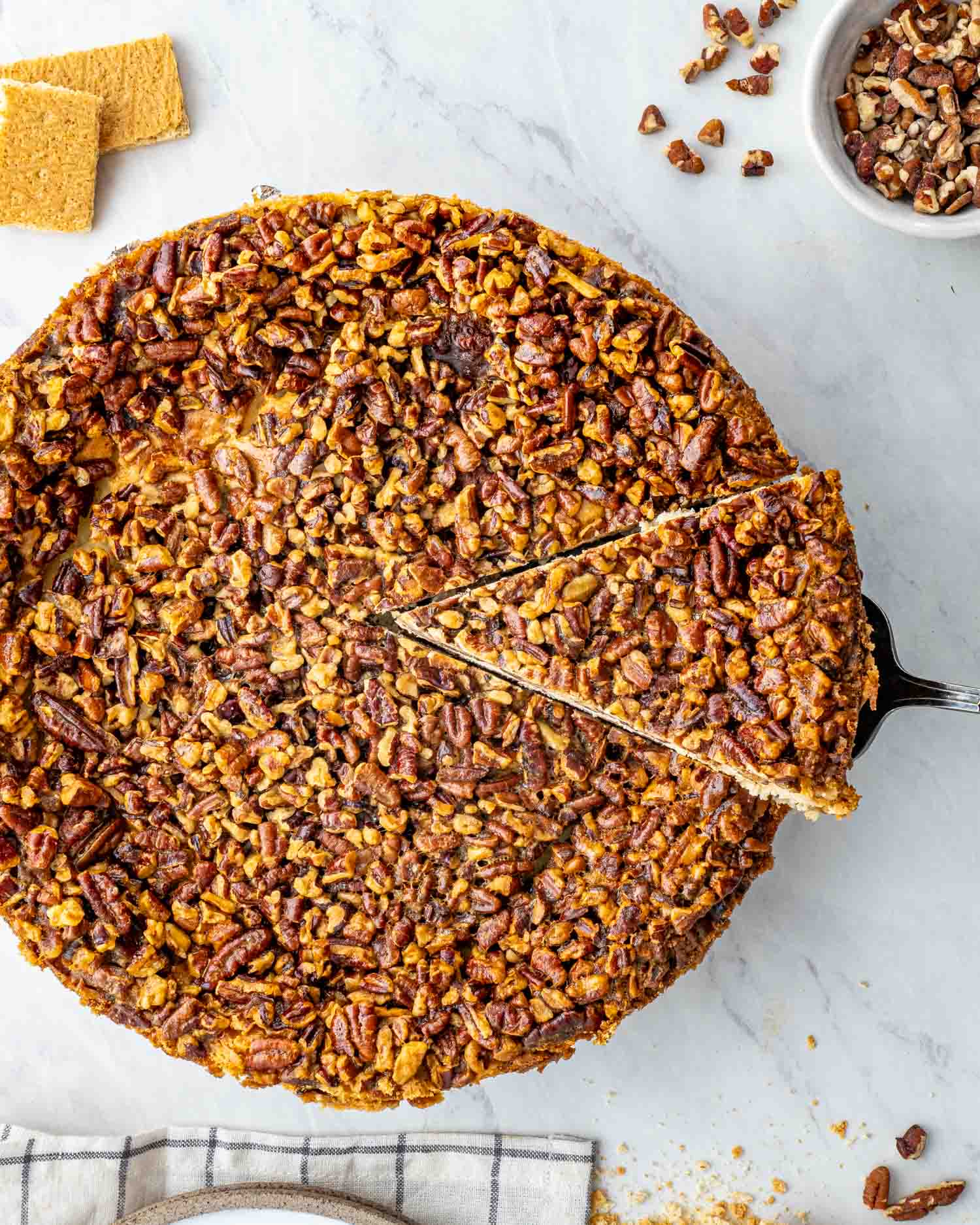 a pecan pie cheesecake with a slice cut out of it.