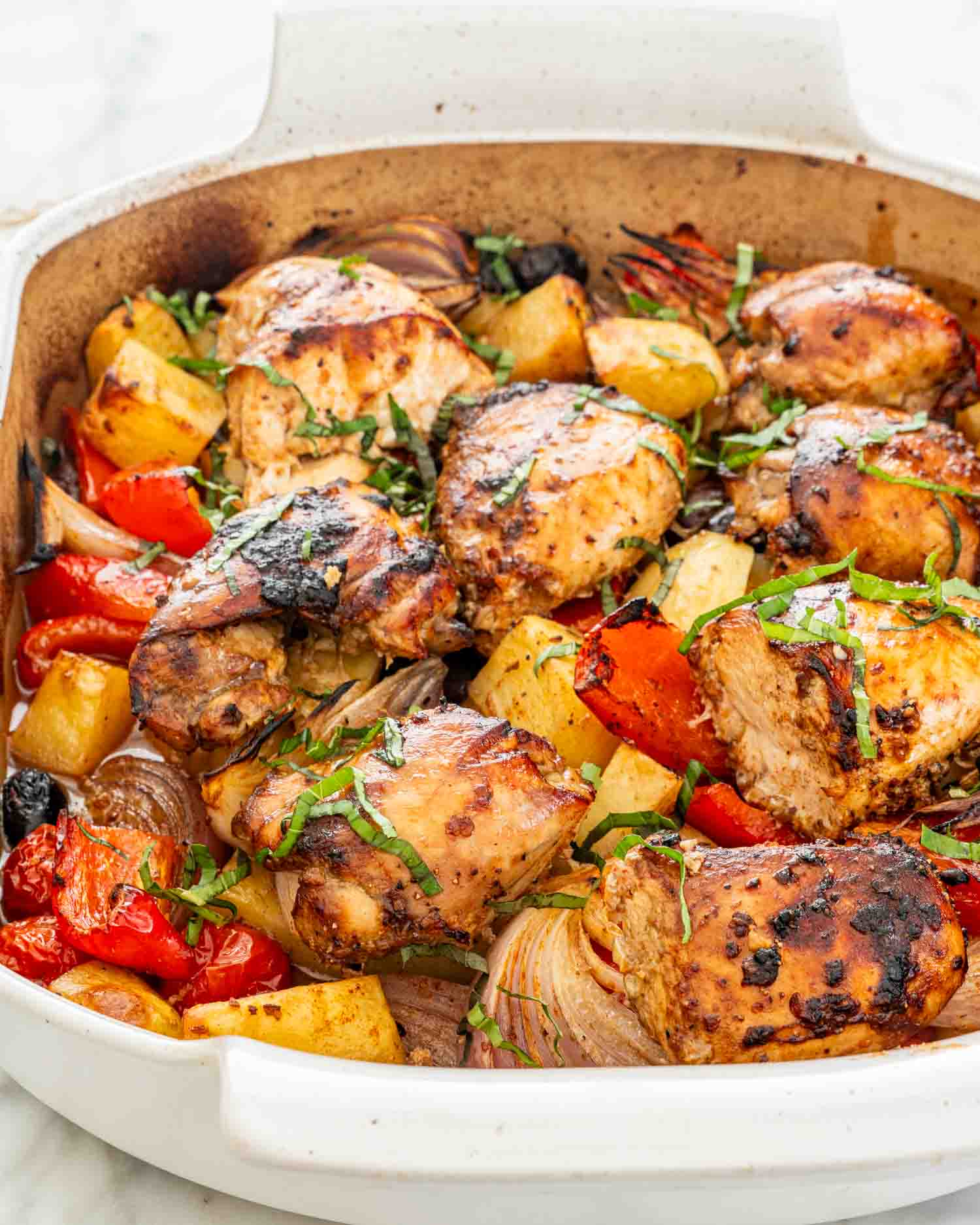 fresh out of the oven, roasted chicken and vegetables in a baking dish.