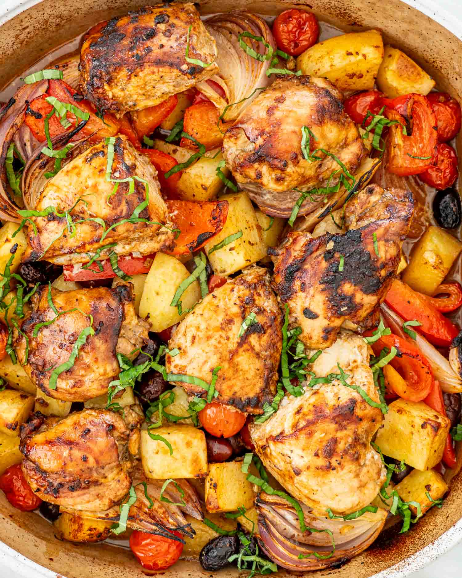 fresh out of the oven, roasted chicken and vegetables in a baking dish.