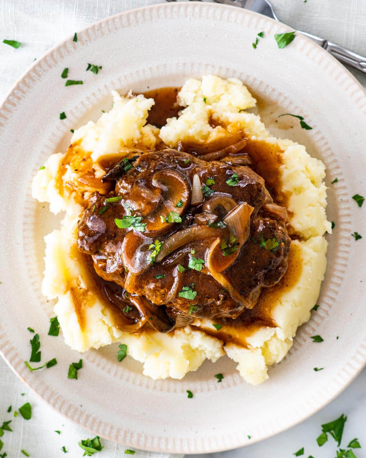 overhead shot of salisbury steak with mushroom gravy over a bed of mashed potatoes